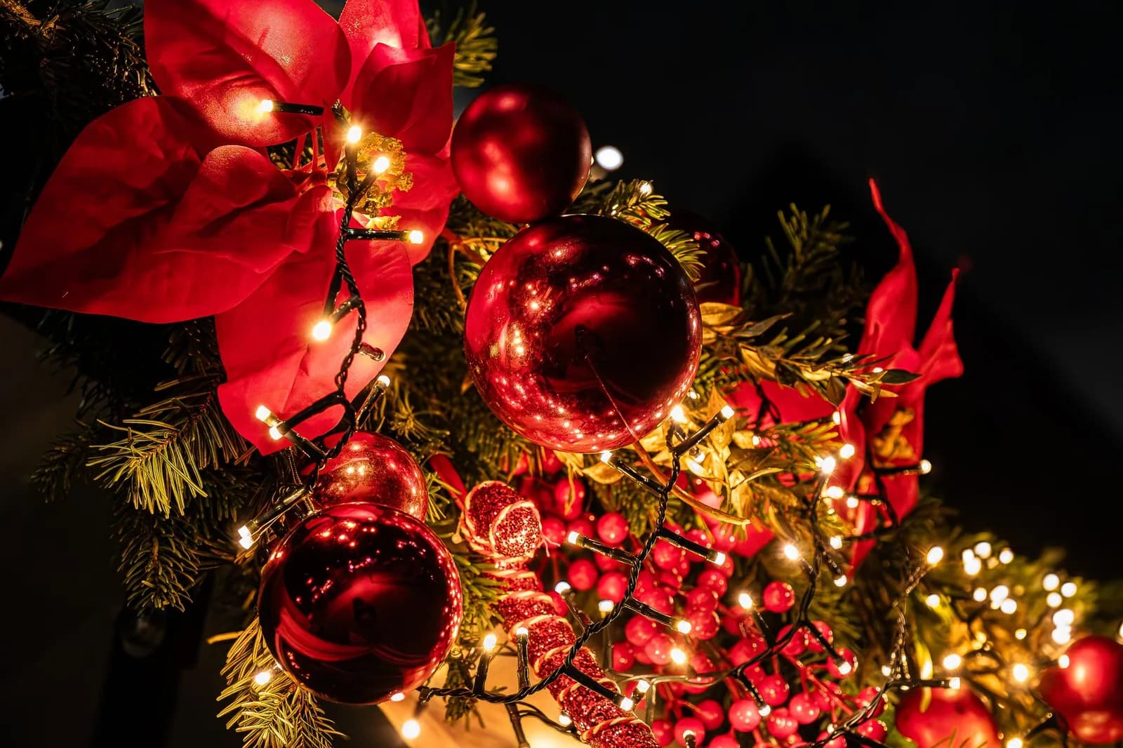 Décorations de Noël : guirlande lumineuse, boules rouges et poinsettia
